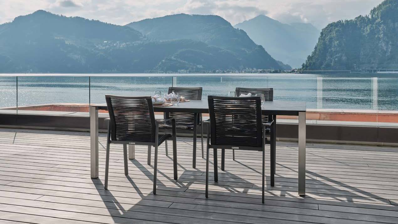 Terrasse en bois gris, table et chaises face au lac et aux montagnes