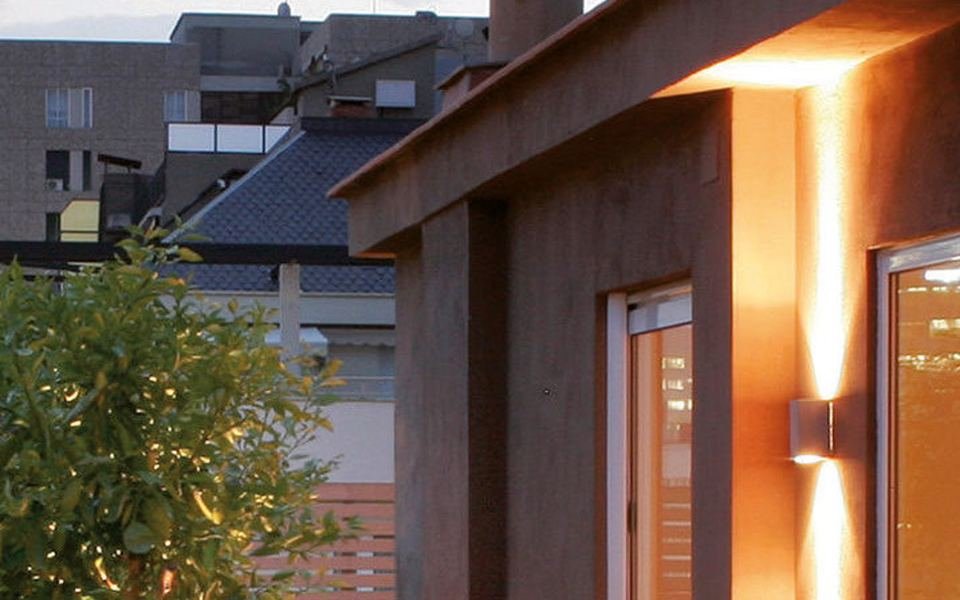 Maison au bardage brun avec terrasse en lames composite assorties