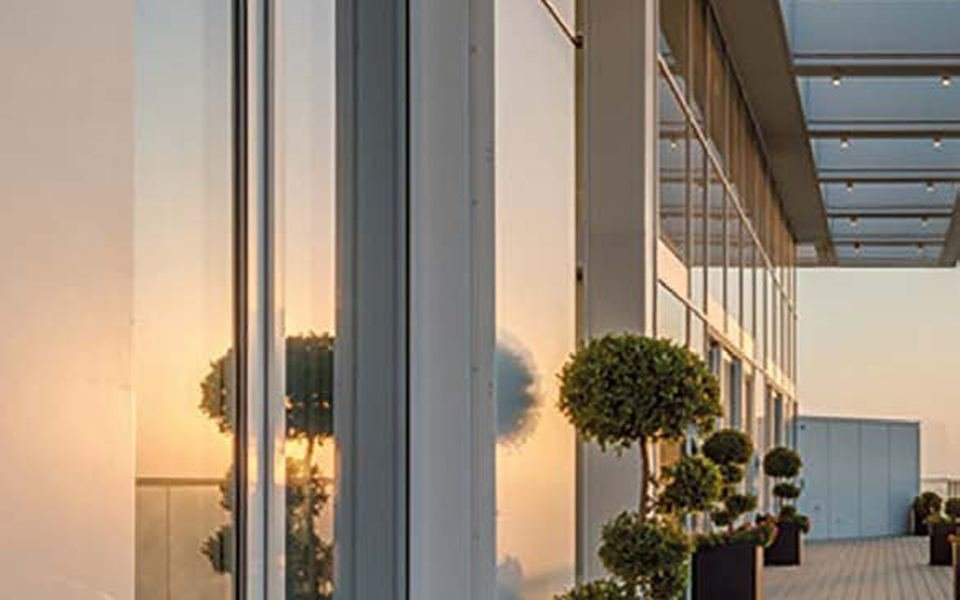 Terrasse en mélèze devant une façade vitrée