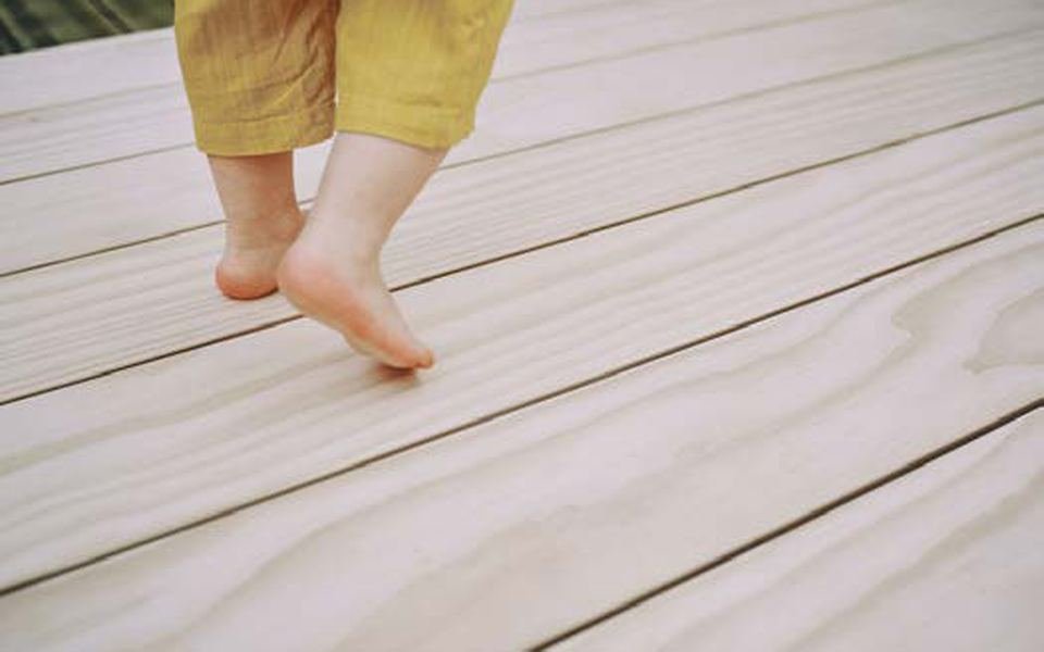 Pieds nus sur des lames de bois Accoya clair