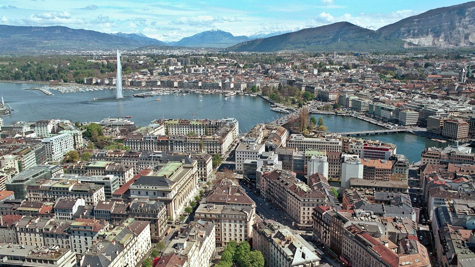 Genève vue du ciel : la rade, le jet d'eau et les toits de la ville, le Salève à l'horizon